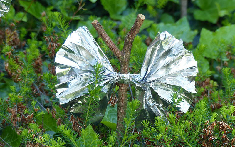 a bow made of aluminum foil tied to a wooden stick