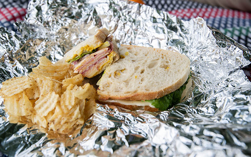 sandwich and chips on an aluminum foil