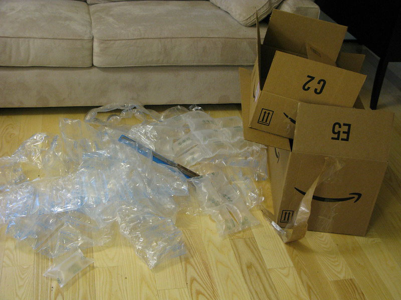 amazon cardboard and plastic packaging on a wooden floor