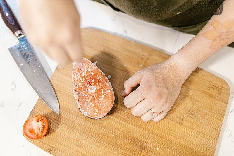 a salmon steak on a bamboo cutting board