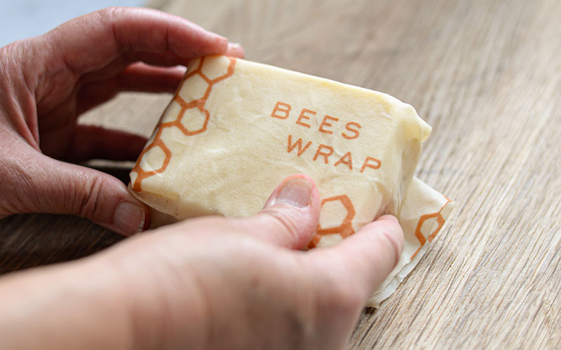 woman wrapping produce in beeswax wrap