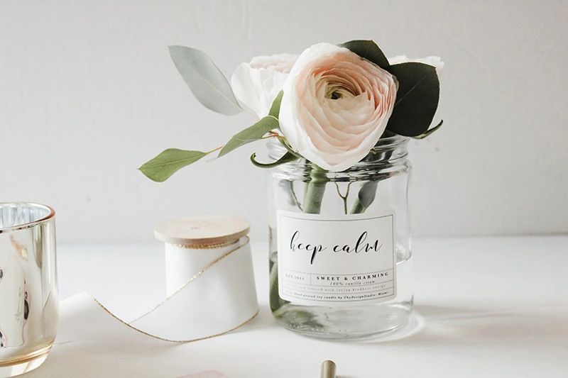 an empty candle jar with fresh flowers