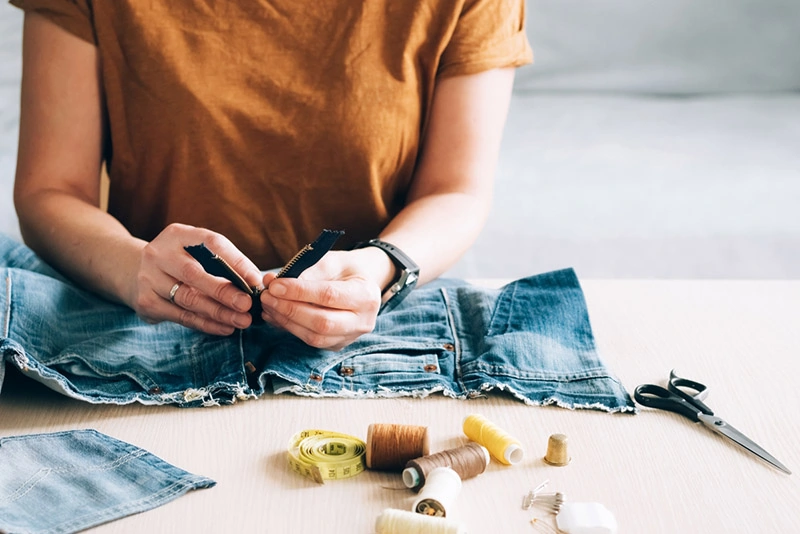 a woman repairing jeans