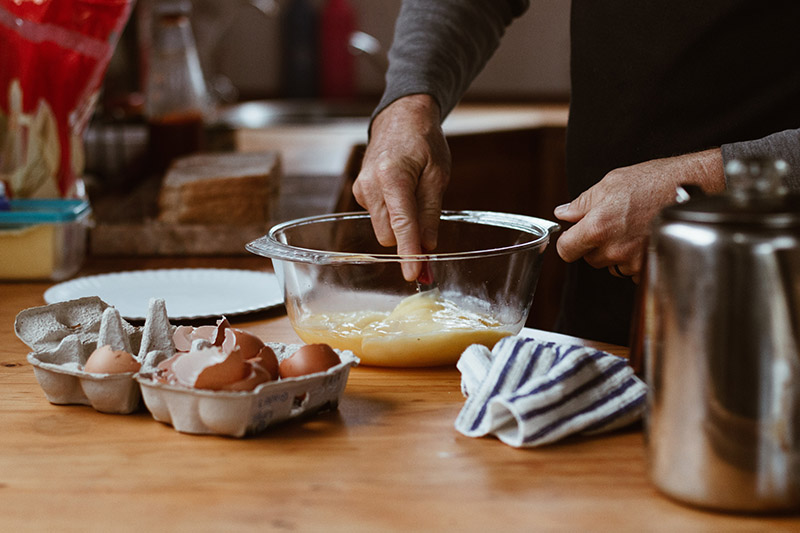 a person cooking eggs at home