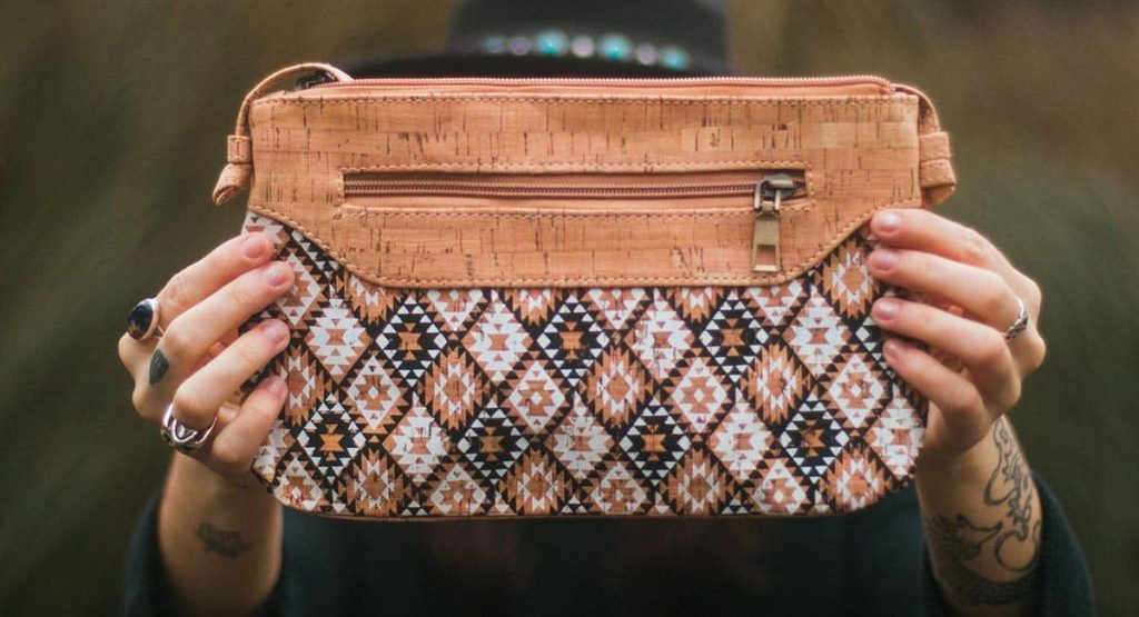 a person holding a handbag made of cork leather