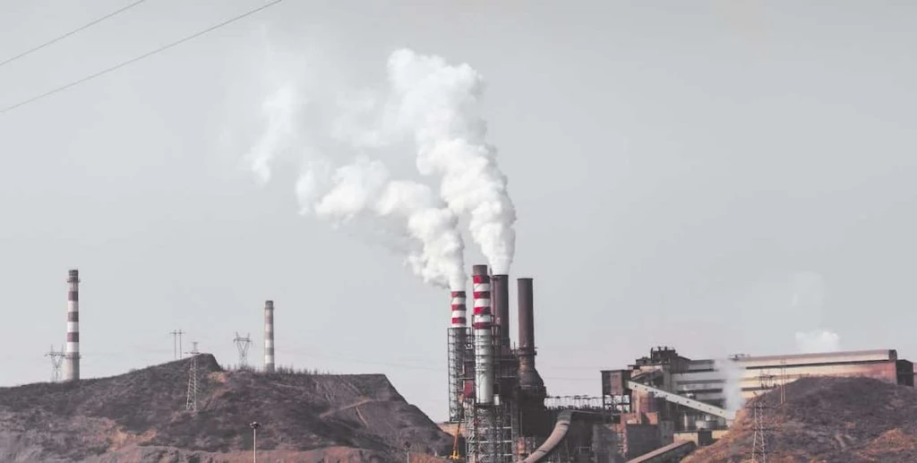 steam coming from the plant that is burning fossil fuels