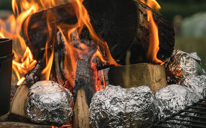 potatoes wrapped in aluminum foil cooked on open fire