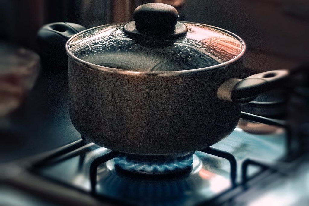 a pan with water boiling on a gas stove