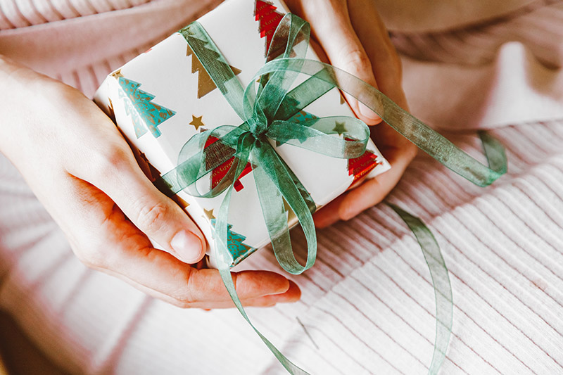 a person holding a gift box wrapped in paper