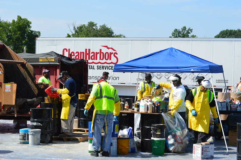 Workers handling flammable liquids at household hazardous waste collection point