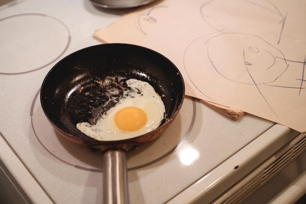 a pan with an egg cooking on an induction stove