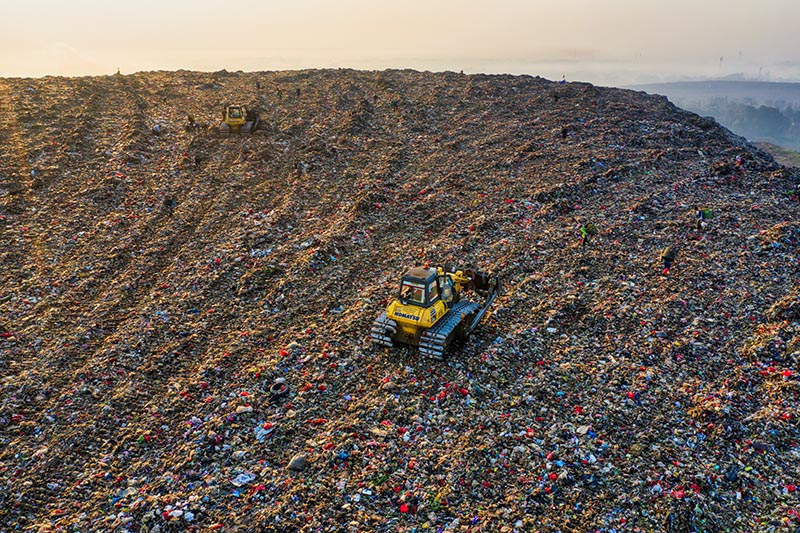 an aerial view of a tractor on a landfill