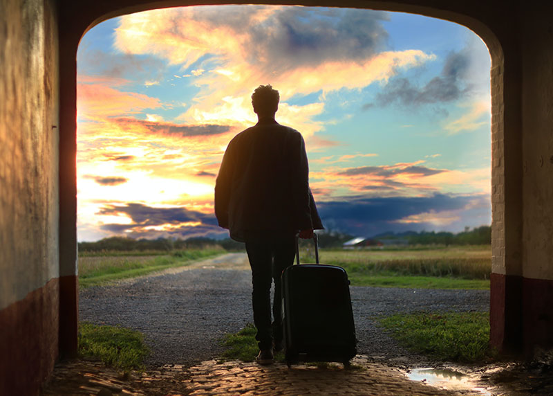 a silhouette of a man with a luggage