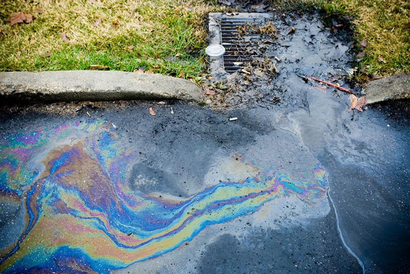 oil spills into a sewer drain