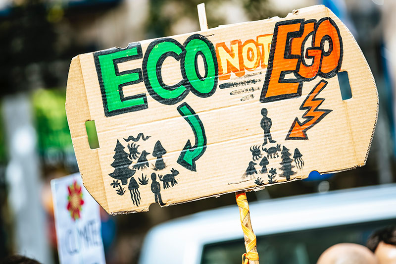 a person holding Eco not Ego sign