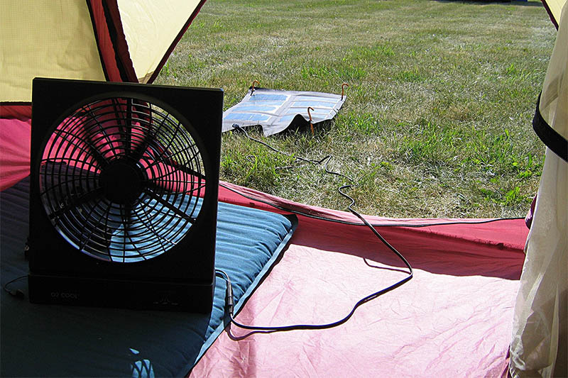 solar powered fan inside a camping tent connected to a solar panel outside