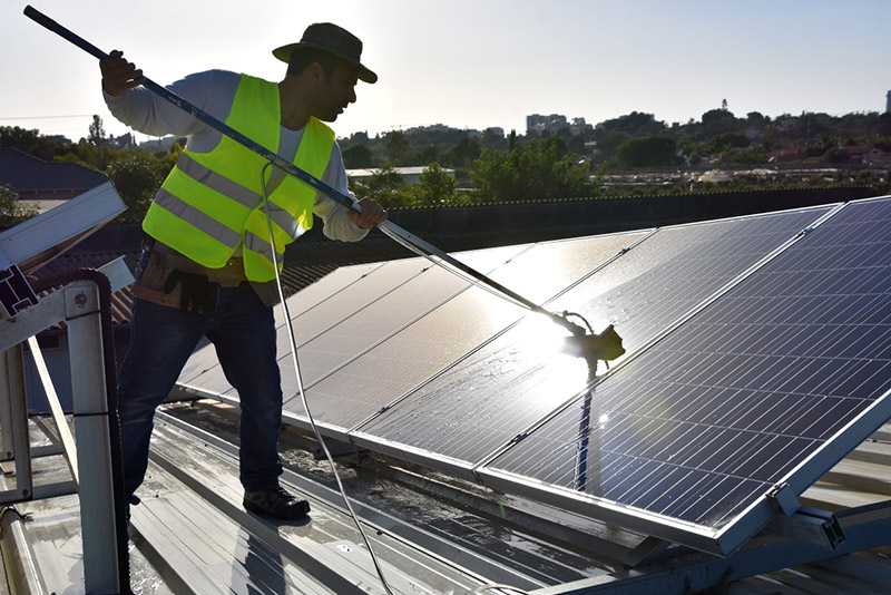 a worker cleaning solar panels