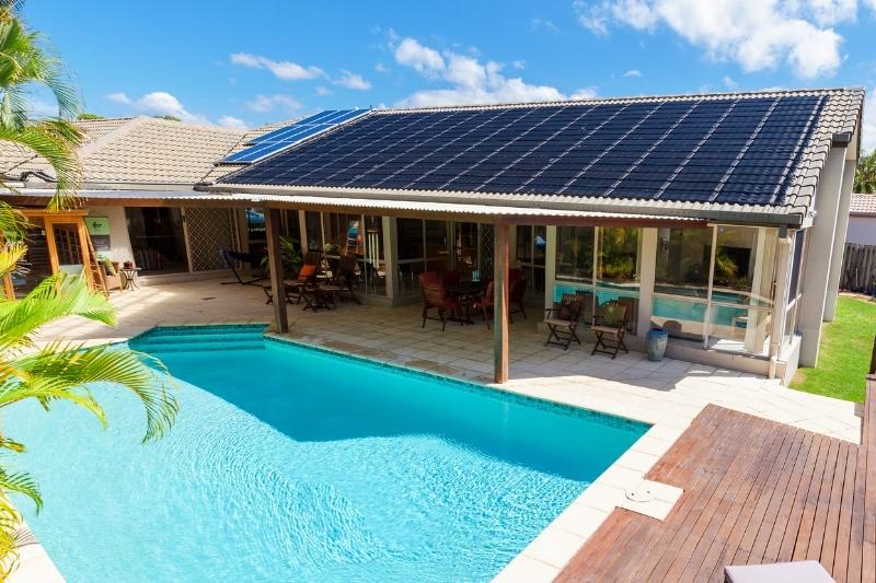 solar water heater panels installed on a roof above the pool