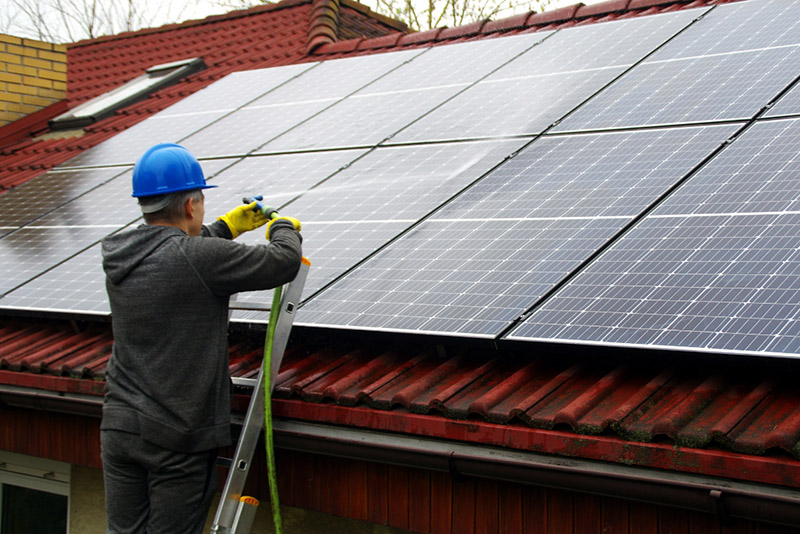 a man spraying water on solar panels