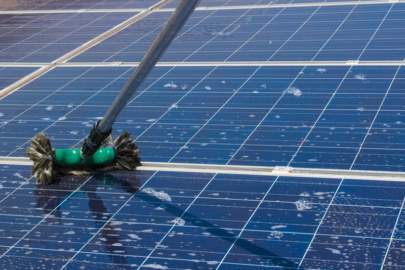 wet brush with soap on the surface of solar panels