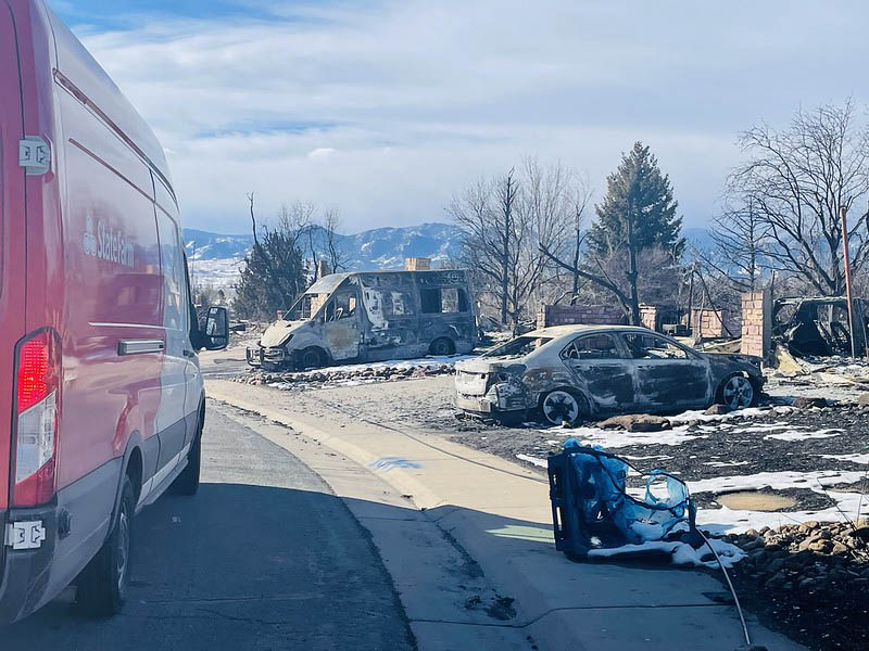 burned cars and buildings' remainings on a residential street