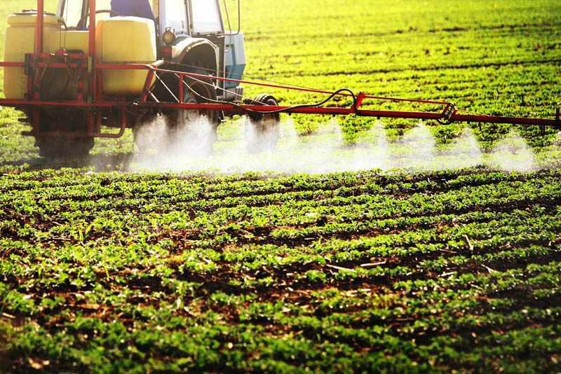 tractor pesticides on a field