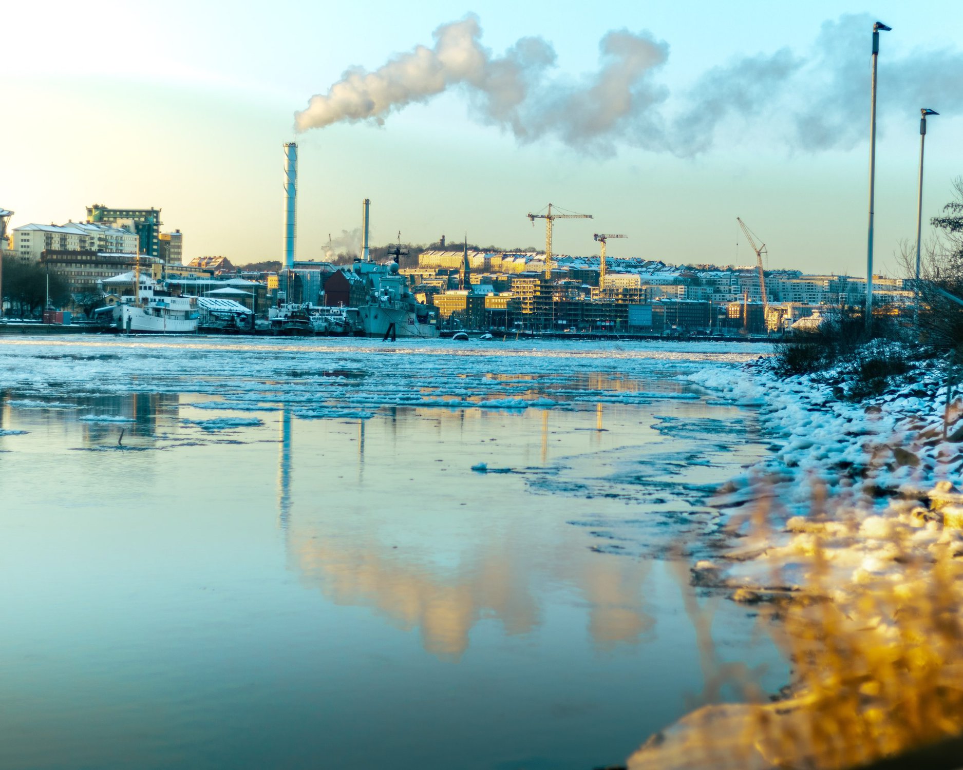 image of a factory next to a polluted waterway