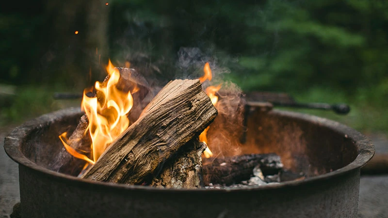 firewood burning in a metal bucket