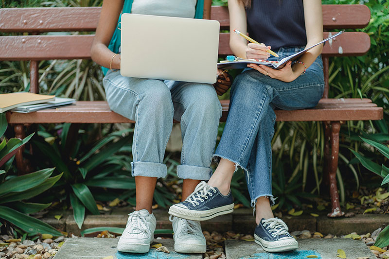 two young girls sitting on a bench