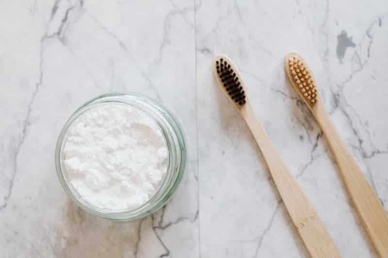 bamboo toothbrushes and zero waste toothpaste in a glass jar